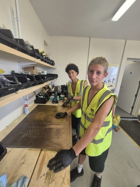 External works team work experience students polishing brass plaque